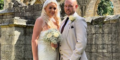 BRIDAL COUPLE POSING OUTSIDE CHURCH