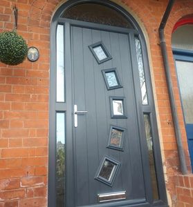 Modern anthracite grey front door with arched frame