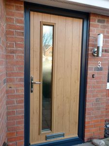Narrow composite front door with solid core upgrade in Irish Oak with a black fame. Fitted in Arnold