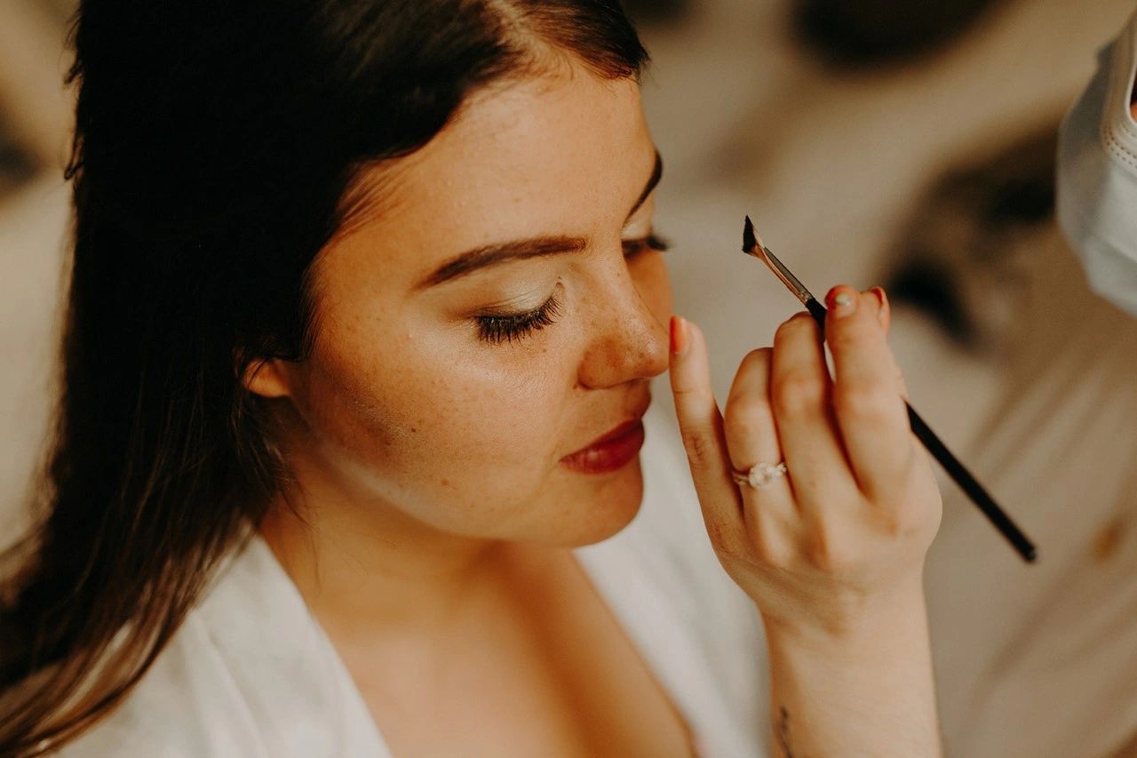 Photo by  Jonathan Ellis Blog. Sabina applying natural makeup to bride at Crondon Park, Essex