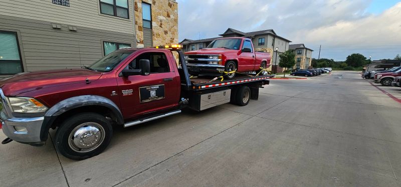 RAK Towing flatbed hauling a red pickup
