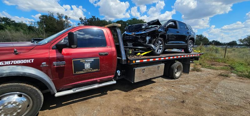 RAK Towing flatbed carrying a damaged car