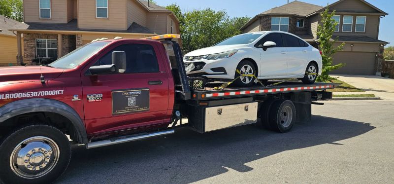 RAK Towing flatbed carrying a white sedan