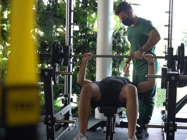 Personal Trainer helping with Squat exercise 