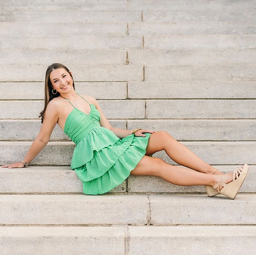 send girl in green dress sitting on concrete steps