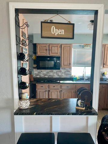 Cozy kitchen view with an open sign and coffee mugs.
