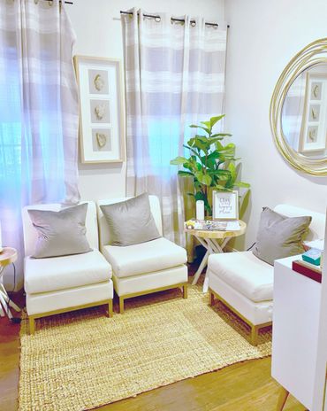 Cozy living room with white chairs, gray cushions, and natural accents.