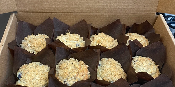 Box of crumb-topped muffins in brown liners.
