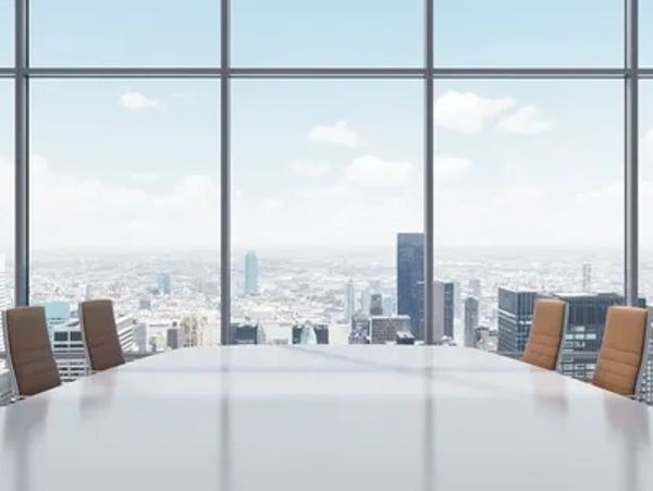 Empty conference room with city skyline view through large windows.