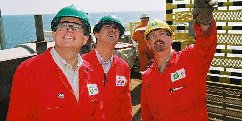 3 men in red pointing up