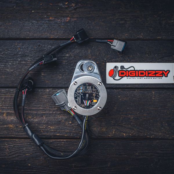 A DigiDizzy digital ignition distributor with wiring harness and logo badge displayed on a dark wooden surface.