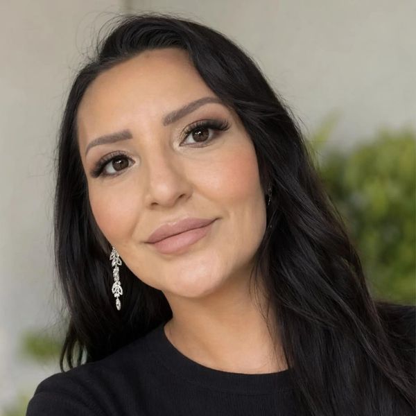 Close-up portrait of a woman with dark hair and elegant earrings.