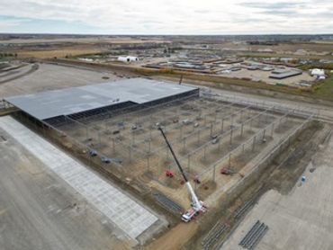 A large construction site with a crane and steel framework in progress.