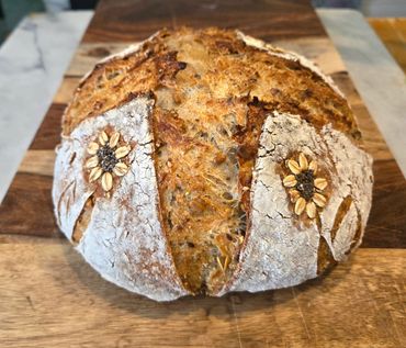 Crusty artisan bread with decorative oats and seeds on top.