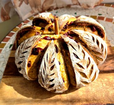 Artisanal bread shaped like a pumpkin with a cinnamon stick.