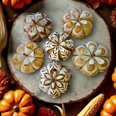 Artisan pumpkin-shaped bread surrounded by autumn decor.
