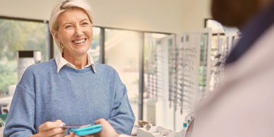 Smiling woman paying with card at a store counter.