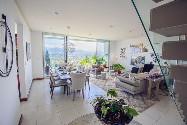 Bright living and dining room with large windows and ocean view.