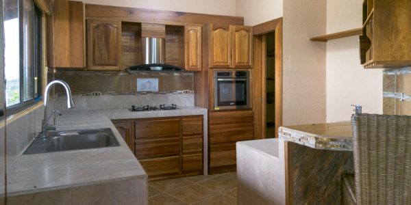 Modern kitchen with wooden cabinets and marble countertops.