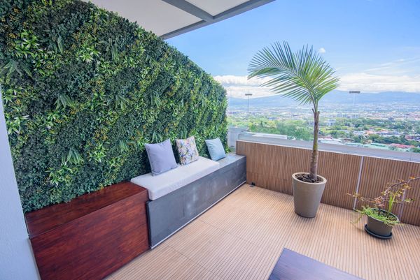 Modern balcony with green wall and city view.