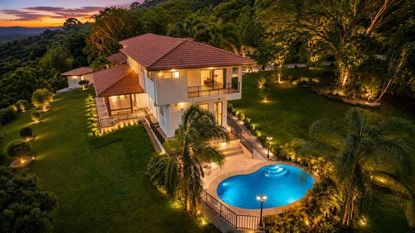 Beautiful illuminated house with a swimming pool at dusk.