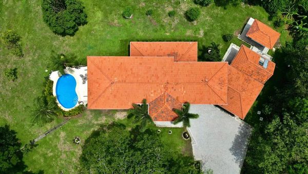 Aerial view of a house with orange roof and a blue swimming pool.