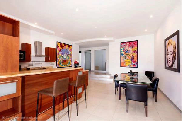 Modern kitchen and dining area with colorful artwork and sleek furniture.