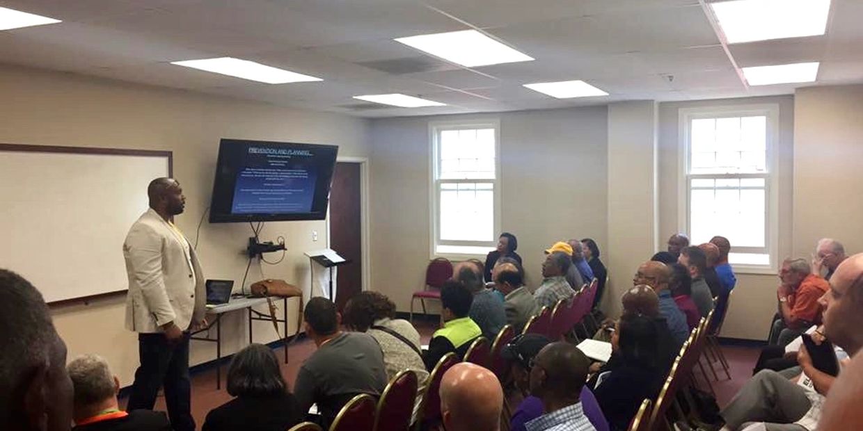 Man giving presentation to seated audience in a classroom.