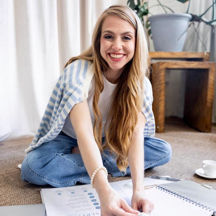 Woman smiling in coastal colors tearing a label off of a label maker organizing 