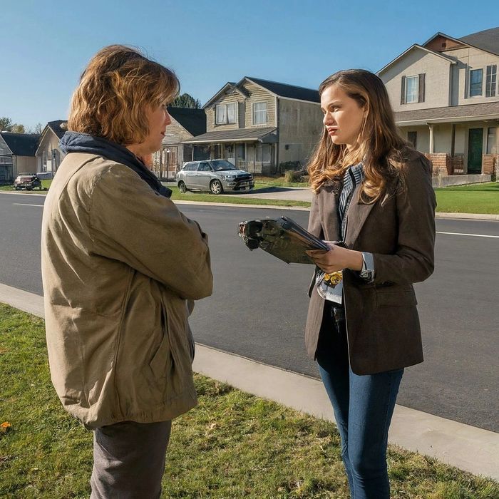 Two women engaged in a serious conversation outside in a suburban neighborhood.