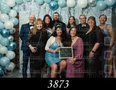 Group of people posing at a formal event under balloon decorations.