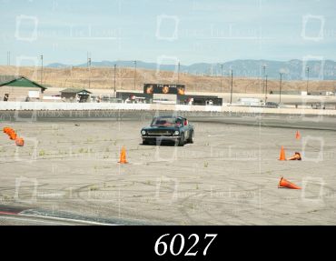 Car driving through cones on a race track.