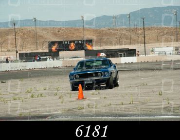 Blue classic car navigating a cone on a race track.