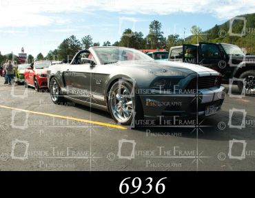 Silver Mustang convertible parked at a car event.