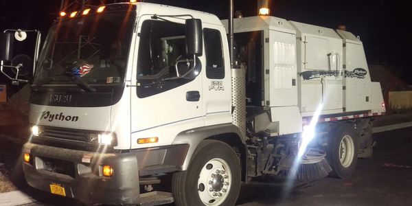 Python Mechanical Broom Street Sweeper working at night.