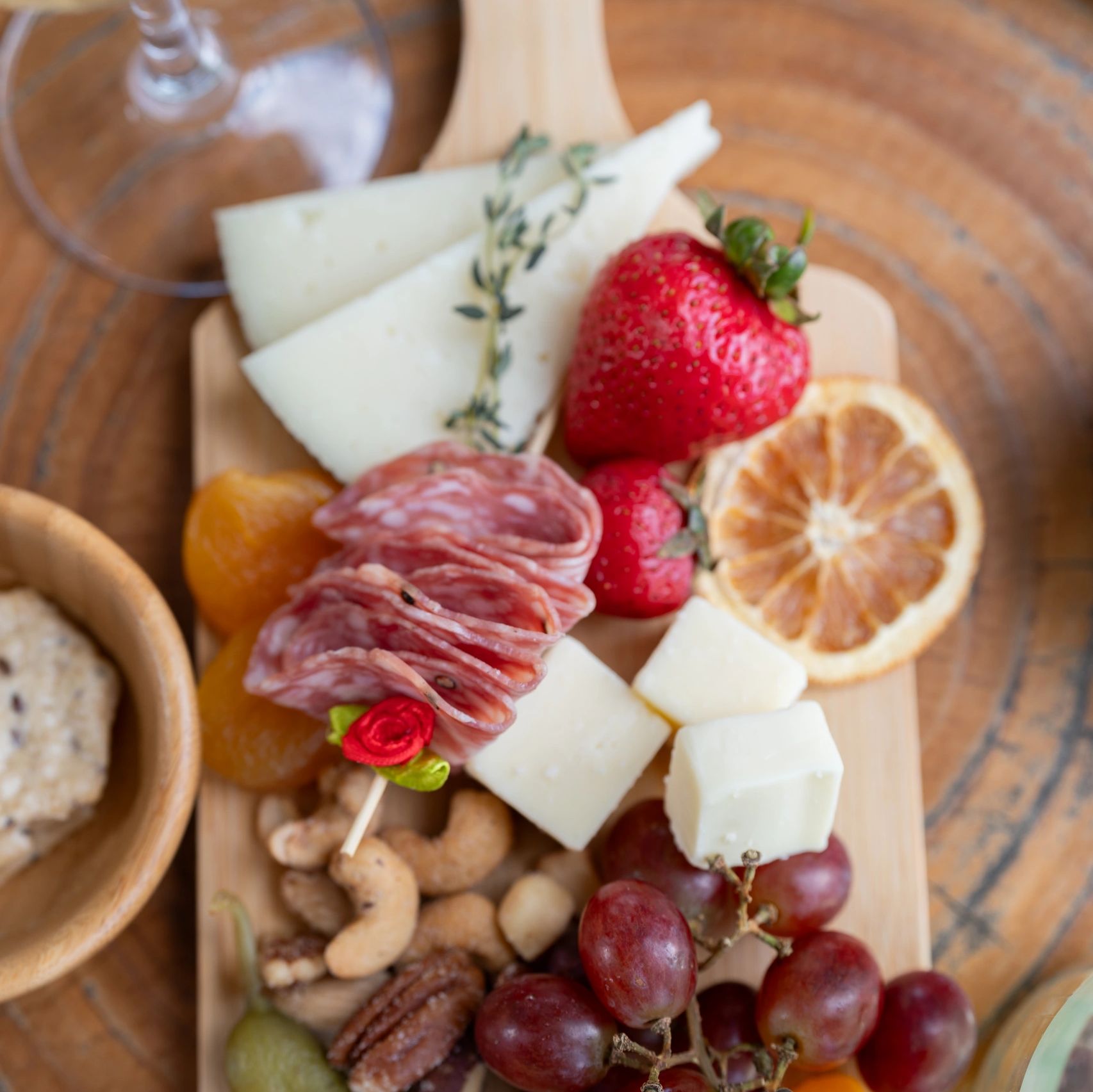 charcuterie board with manchego, strawberry, salami, cashews, grapes