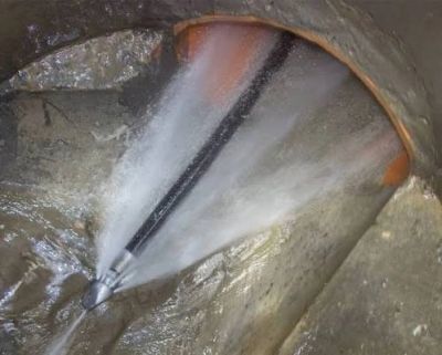 Water spraying from a pipe inside a sewer or drain.