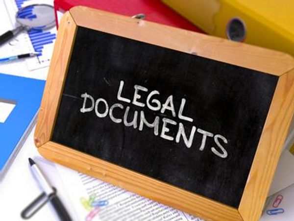 A mini blackboard with "LEGAL DOCUMENTS" written on it, surrounded by office supplies.