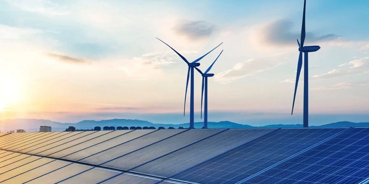 Wind turbines and solar panels at sunset.
