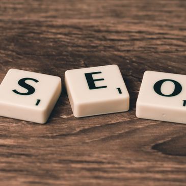 White scrabble tiles spelling out SEO on a brown wooden table