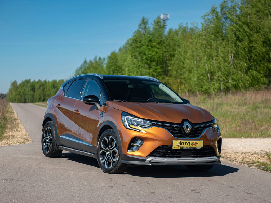 Renault Captur w kolorze złoty metalik stoi prawym przodem ze skręconymi kołami na asfaltowej drodze