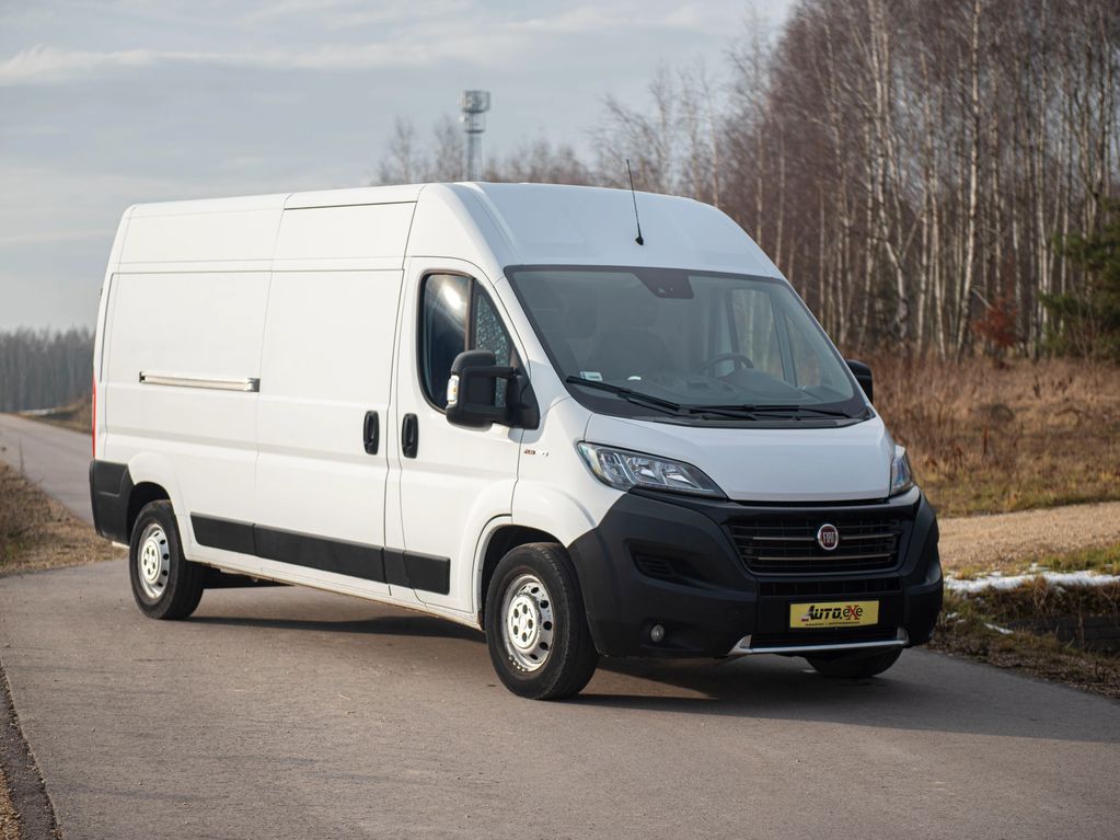 Fiat Ducato BUS kolor biały stoi przednim prawym bokiem na drodze asfaltowej obok trawy