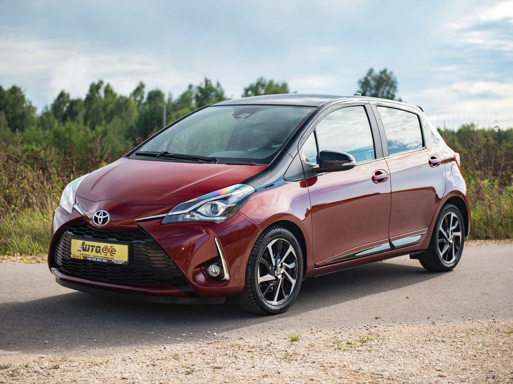 toyota Yaris III bordo perła stoi przednim lewym na drodze asfaltowej z lekko skręconymi kołami