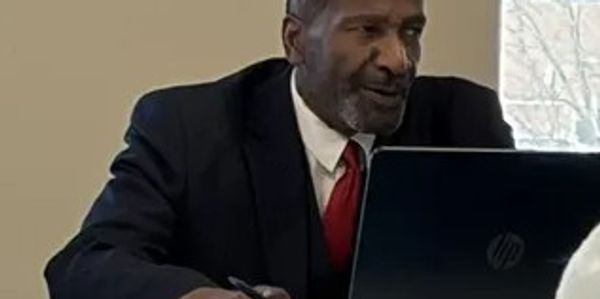 Man in suit working on laptop.