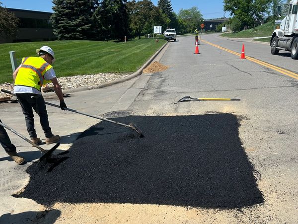 Brother Built crew raking asphalt patch