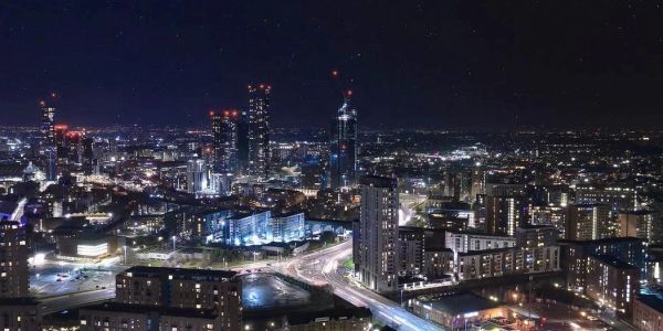 City skyline at night with illuminated buildings and streets.