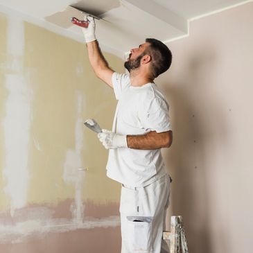 man doing sheetrock repair on ceiling 