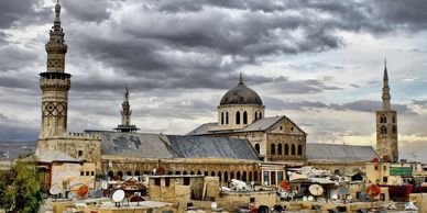 Historic mosque with dramatic cloudy sky backdrop.
