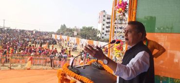Man addressing a large outdoor crowd.