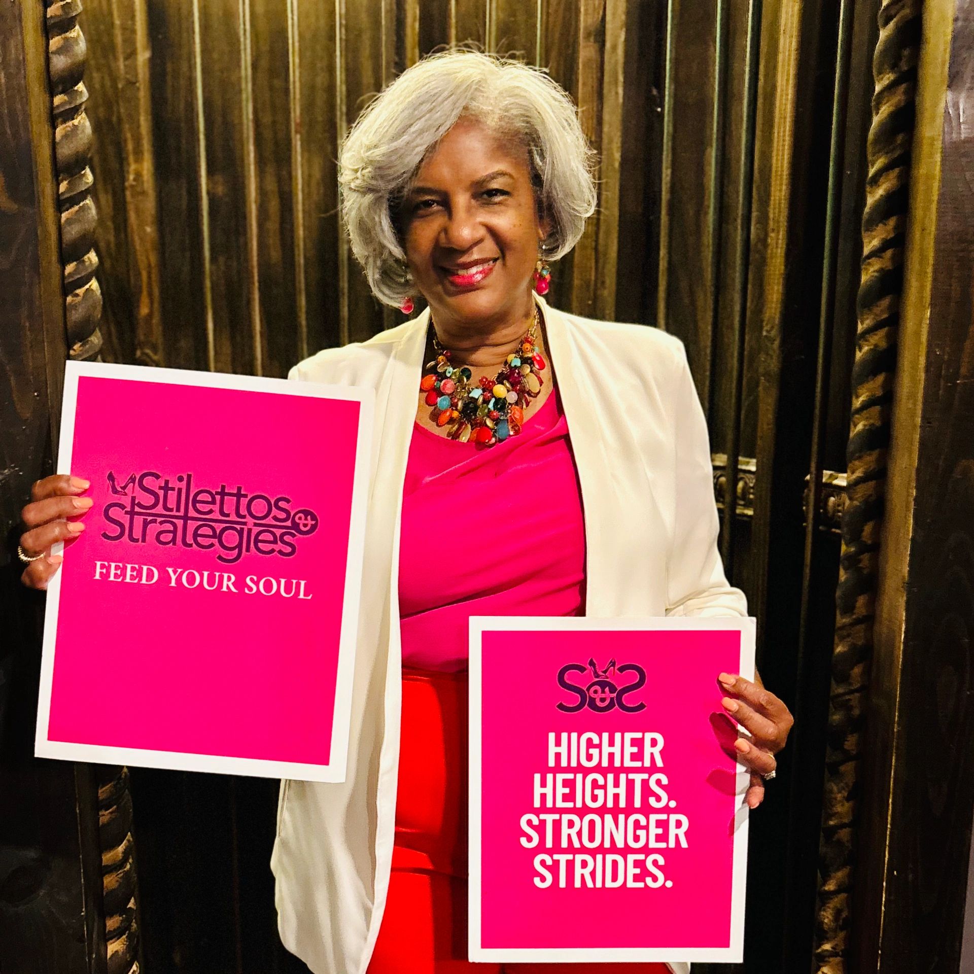 Woman holding two pink slogans with confidence.